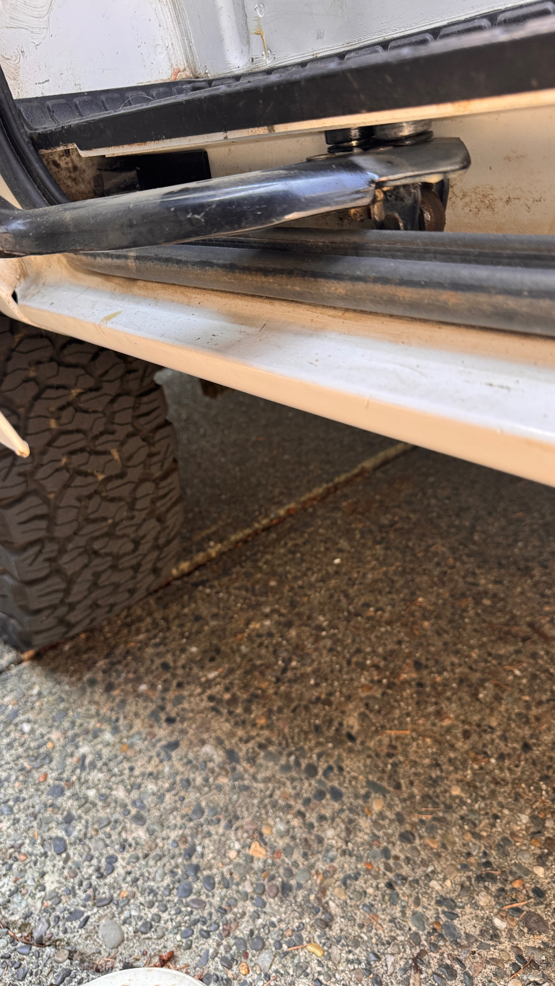 Wider view of the sagged sliding door meeting the rocker — check strike alignment and body-line gap when the roller is worn.