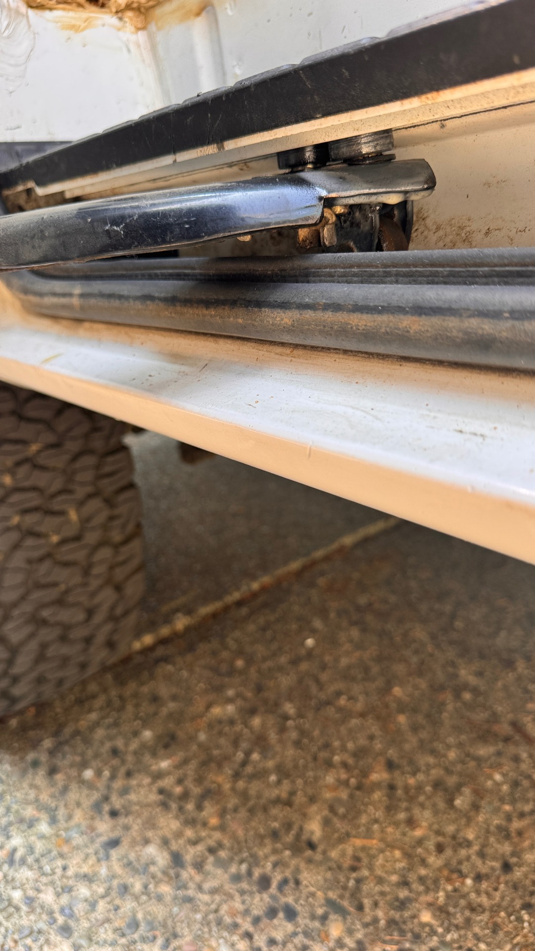 Center roller arm at track height — door dropped onto the lower guide. Weatherstrip and rocker pinch point visible.